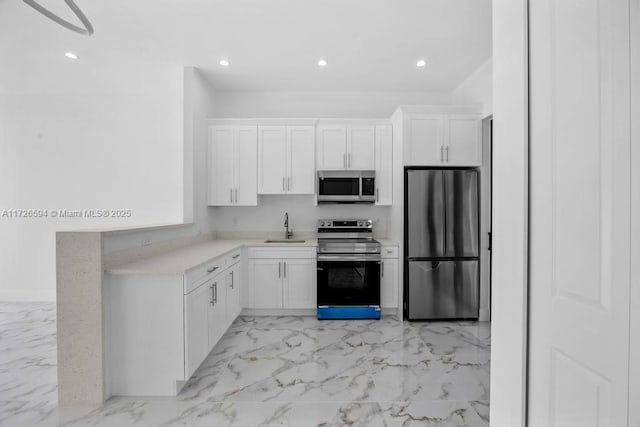 kitchen with stainless steel appliances, white cabinetry, and sink