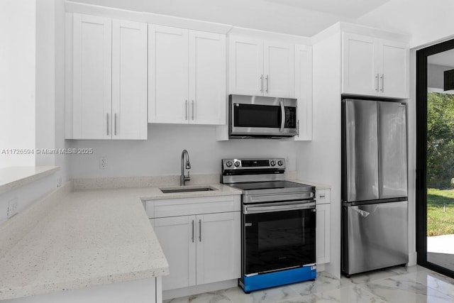 kitchen featuring light stone countertops, white cabinetry, appliances with stainless steel finishes, and sink