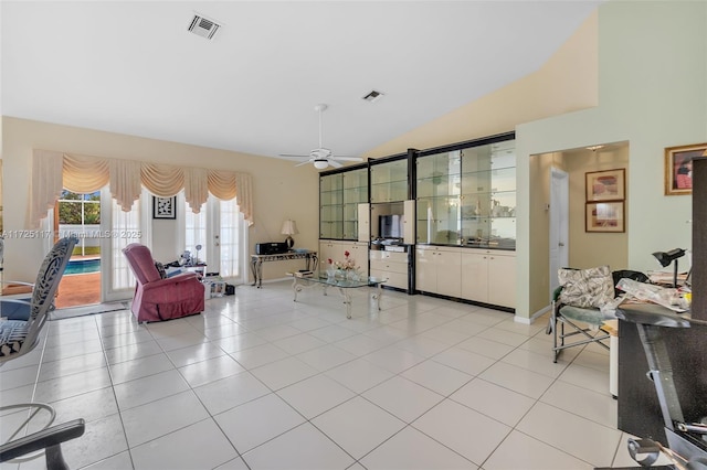 tiled living room featuring ceiling fan and vaulted ceiling