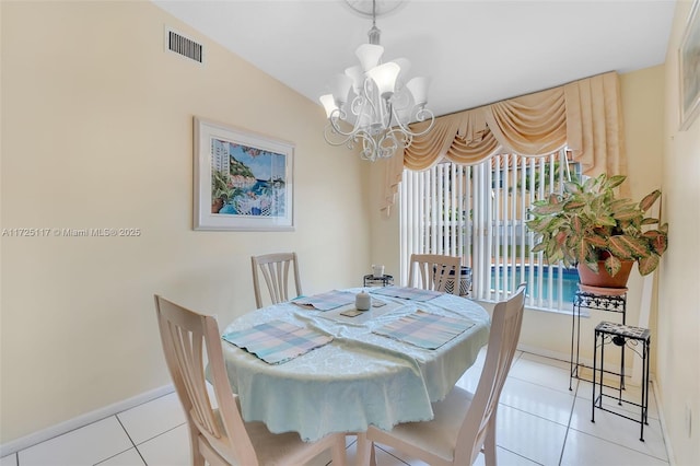 tiled dining space with lofted ceiling and an inviting chandelier