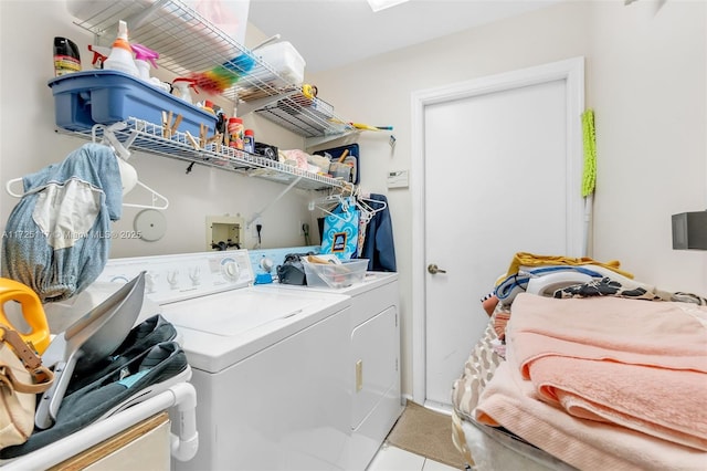 laundry area with washer and clothes dryer and light tile patterned flooring