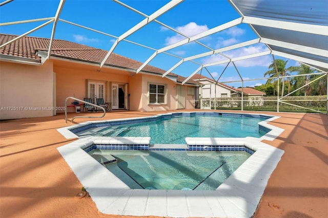 view of pool with a lanai, french doors, an in ground hot tub, and a patio area