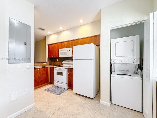 kitchen featuring electric panel, white appliances, light tile patterned flooring, tasteful backsplash, and stacked washer / drying machine