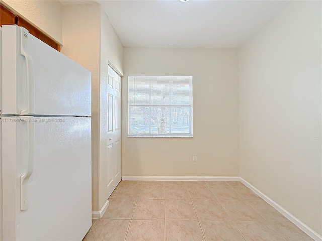 kitchen with white fridge and light tile patterned flooring