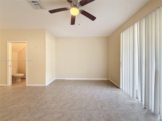 spare room with ceiling fan and light tile patterned floors