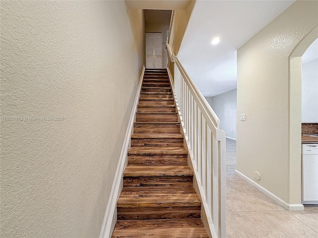 stairway featuring tile patterned flooring