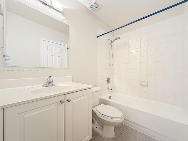 full bathroom featuring tile patterned flooring, tiled shower / bath combo, vanity, and toilet