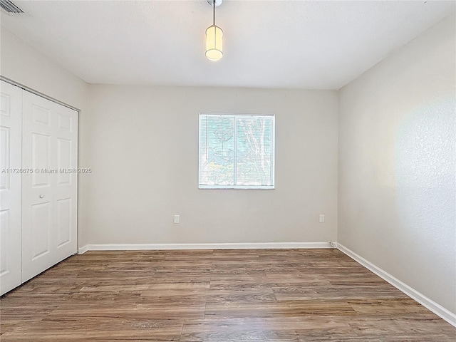 unfurnished bedroom with a closet and hardwood / wood-style flooring