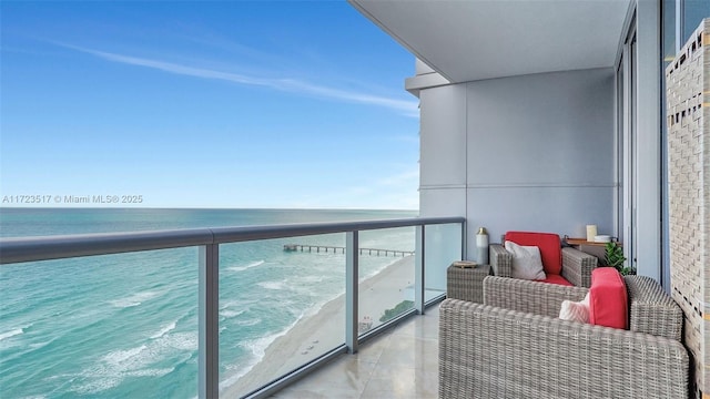 balcony featuring a beach view and a water view