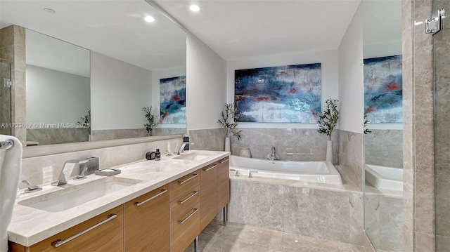 bathroom with vanity, tile patterned flooring, and tiled bath