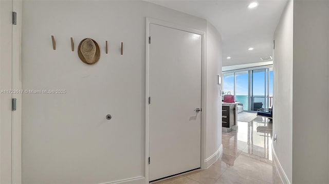 hallway with expansive windows and a water view