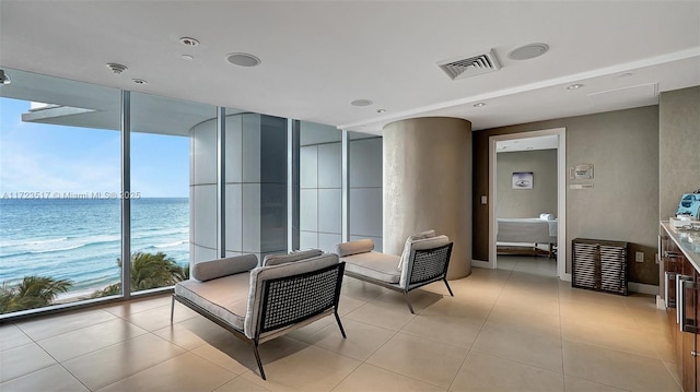 interior space with a beach view and a water view