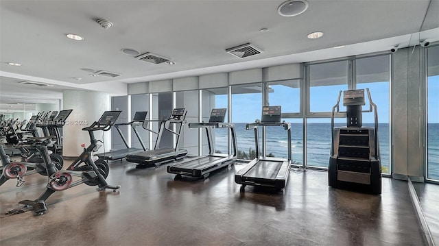 gym featuring a wall of windows and a water view