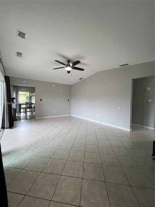 empty room featuring ceiling fan, lofted ceiling, and light tile patterned floors