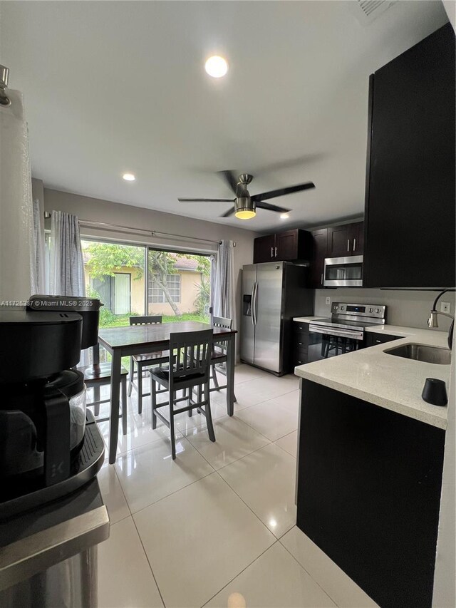 9541 W Daffodil Ln Unit 0, Miramar, FL 33025 - kitchen with appliances with stainless steel finishes, a sink, dark cabinets, light tile patterned flooring, and ceiling fan