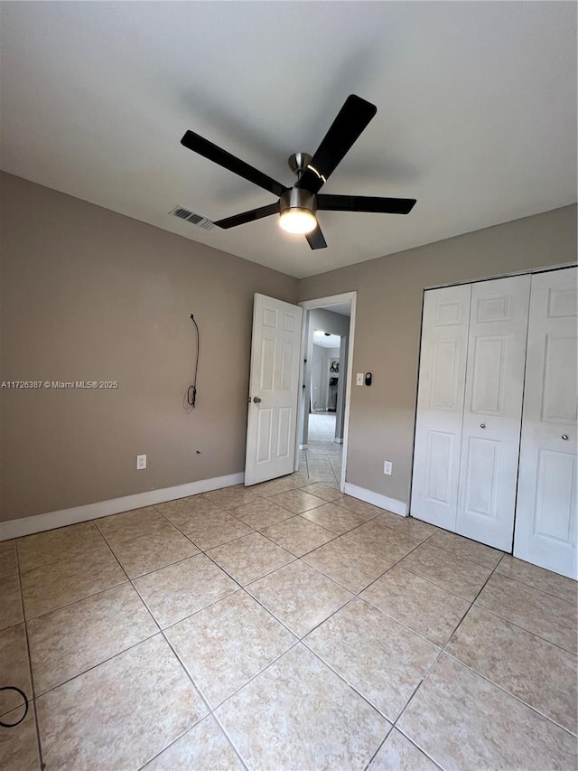 unfurnished bedroom featuring light tile patterned flooring, ceiling fan, and a closet