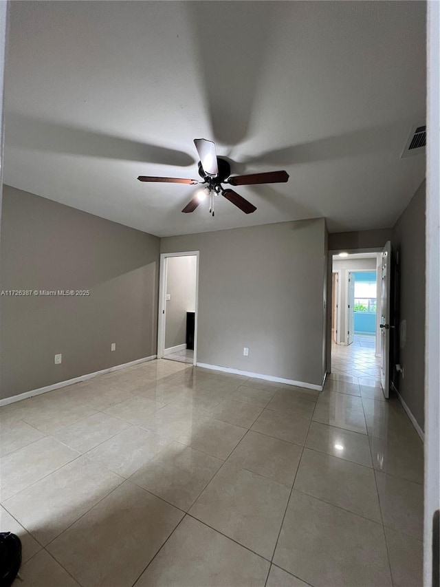 tiled spare room featuring ceiling fan