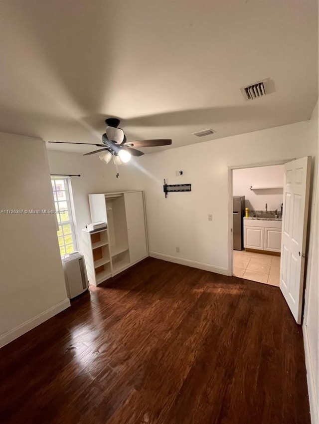 unfurnished living room featuring ceiling fan and wood-type flooring