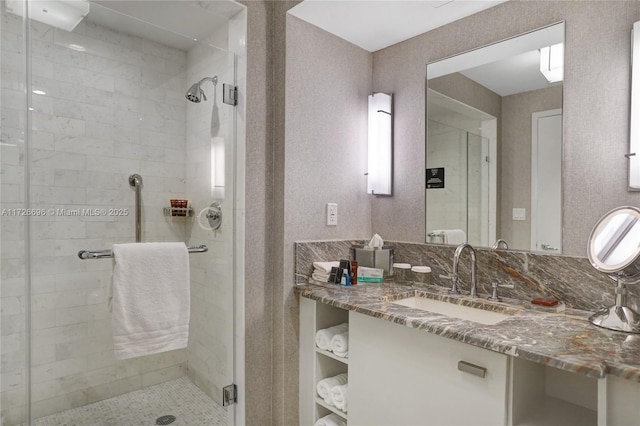 bathroom with a shower with shower door and vanity