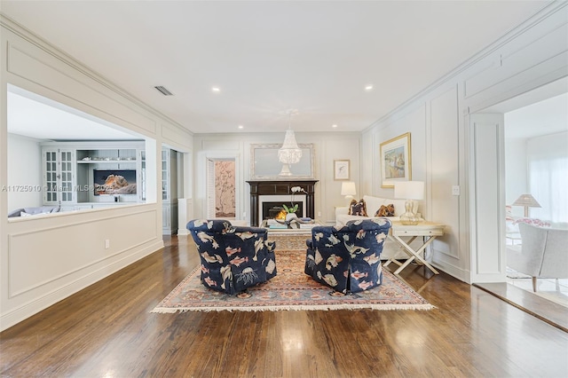 living room with built in shelves, dark hardwood / wood-style floors, and crown molding