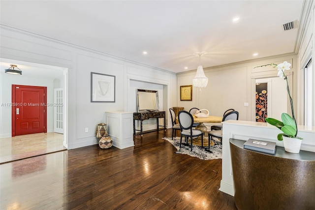 dining space with dark wood-type flooring and crown molding