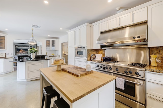 kitchen with decorative light fixtures, white cabinetry, stainless steel appliances, and tasteful backsplash