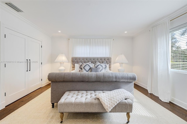 bedroom with dark hardwood / wood-style flooring and crown molding