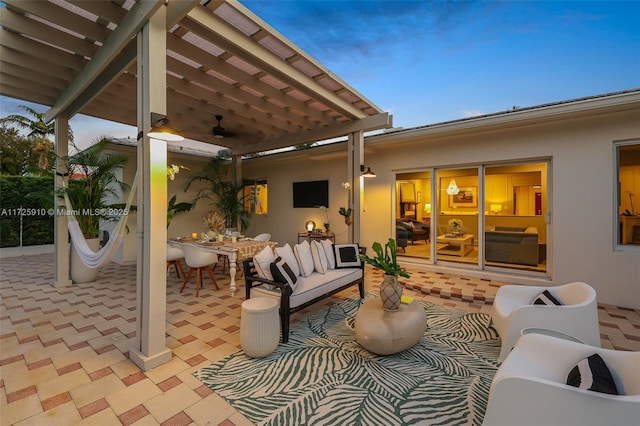 patio terrace at dusk with ceiling fan, outdoor lounge area, and a pergola