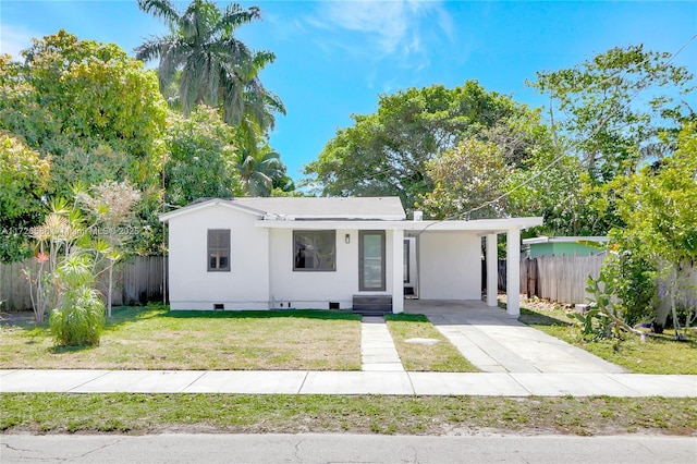 view of front of property featuring crawl space, a carport, a front lawn, and fence