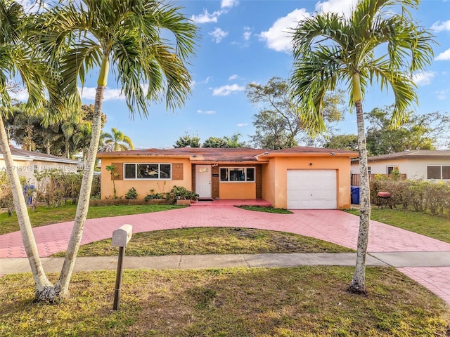 ranch-style house with a garage and a front lawn