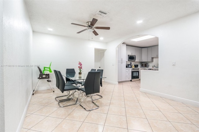 tiled dining space with ceiling fan and a textured ceiling