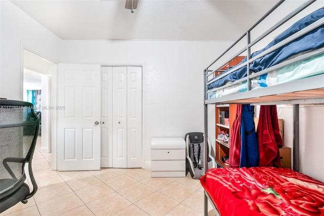 tiled bedroom featuring ceiling fan and a closet