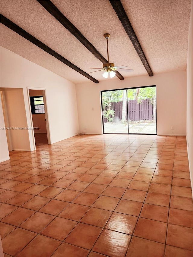 empty room with a textured ceiling, lofted ceiling with beams, ceiling fan, and light tile patterned floors