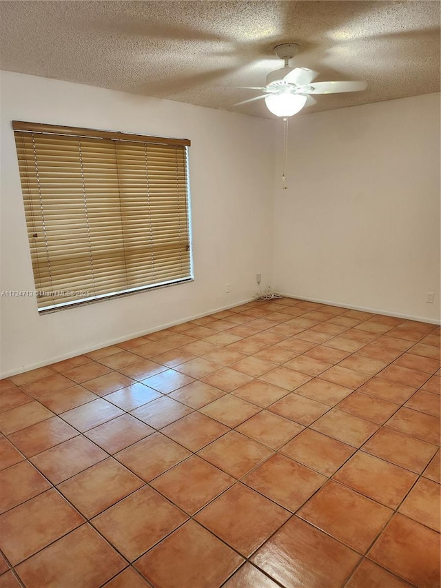 tiled empty room featuring a textured ceiling and ceiling fan