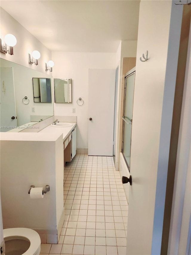 full bathroom featuring enclosed tub / shower combo, vanity, tile patterned floors, and toilet