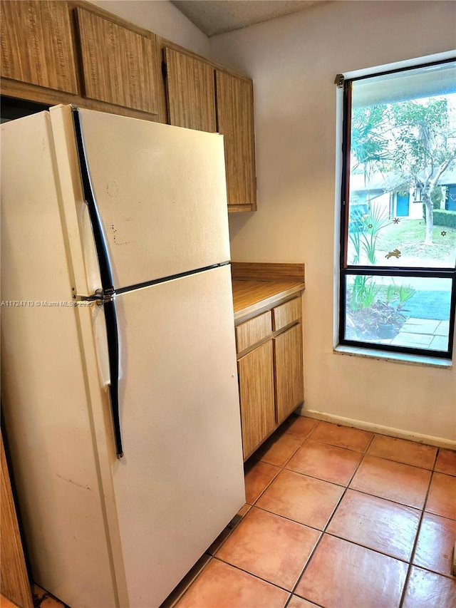 kitchen featuring white refrigerator and light tile patterned floors