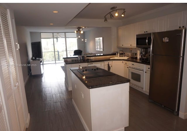 kitchen featuring stainless steel appliances, sink, white cabinetry, ceiling fan, and kitchen peninsula