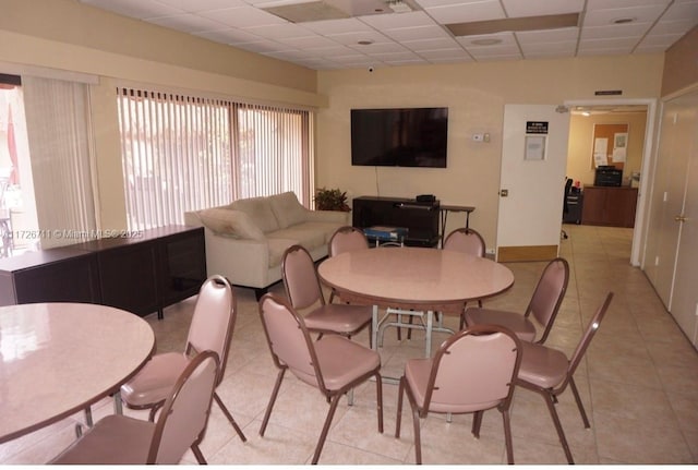 dining room featuring light tile patterned flooring and a drop ceiling