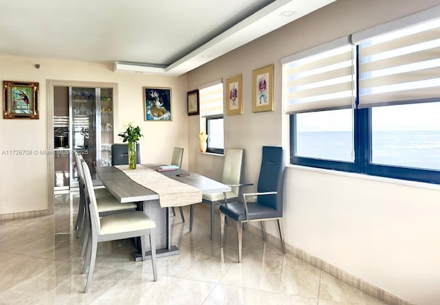 tiled dining room featuring a water view