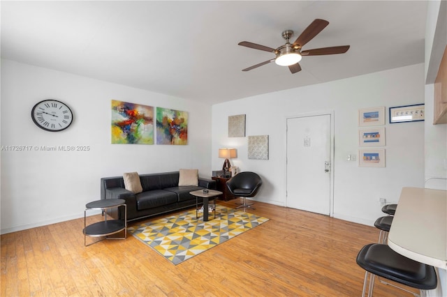 living room with light wood-type flooring and ceiling fan