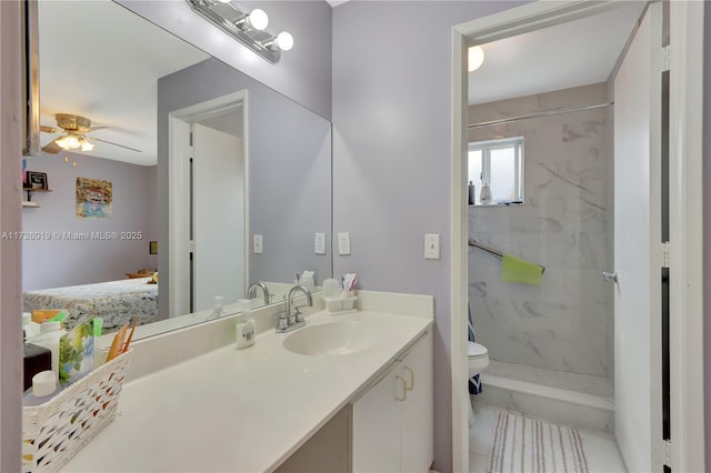 bathroom with tile patterned flooring, vanity, toilet, ceiling fan, and a tile shower