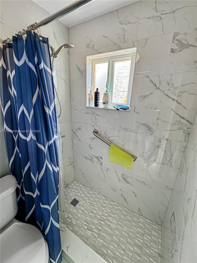 bathroom featuring toilet and curtained shower