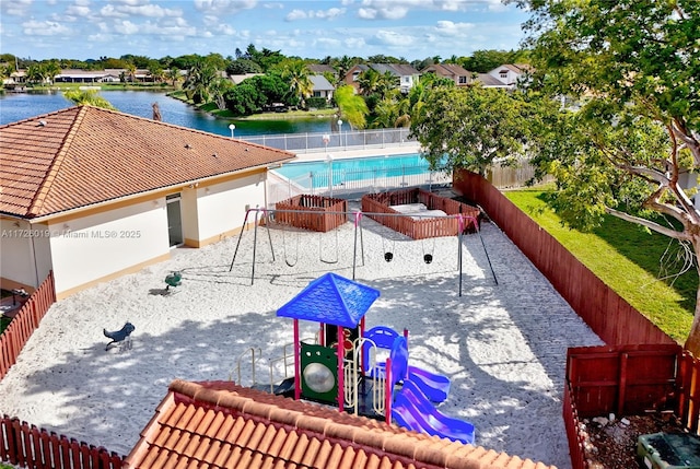 view of swimming pool featuring a water view and a playground