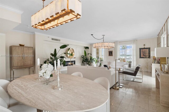 dining area with a chandelier and crown molding