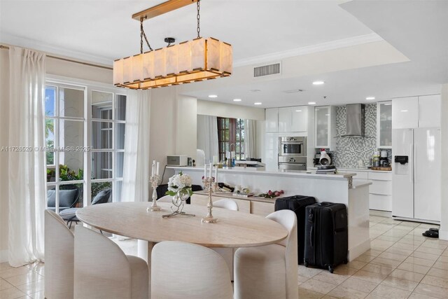 dining area featuring light tile patterned flooring and crown molding