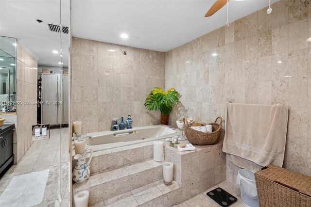 bathroom with tile walls, shower with separate bathtub, ceiling fan, and vanity