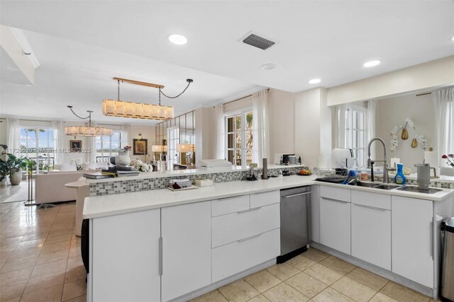 kitchen featuring white fridge with ice dispenser, double oven, white cabinets, wall chimney range hood, and backsplash