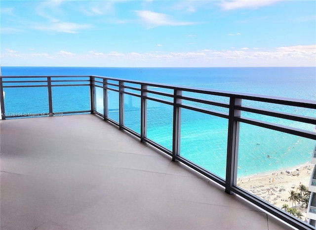 balcony featuring a beach view and a water view