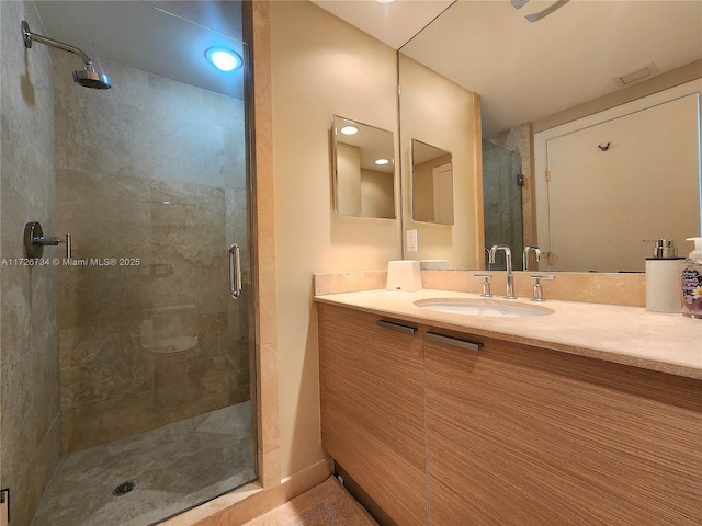 bathroom featuring vanity and a shower with door