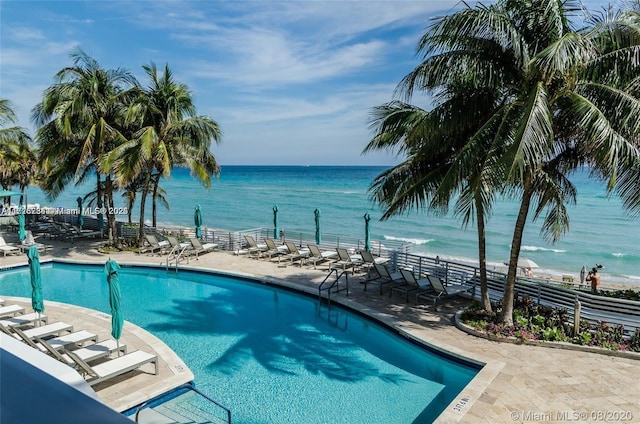 view of pool with a patio area and a water view